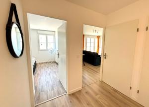 a hallway with a mirror and a living room at Cartier Disney 7min Train 6min Paris parking in Serris