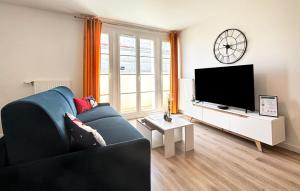 a living room with a blue couch and a flat screen tv at Cartier Disney 7min Train 6min Paris parking in Serris