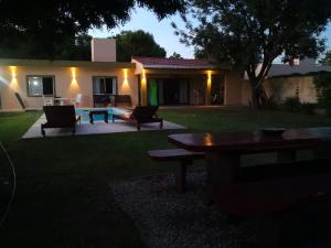 a backyard with a table and chairs and a house at Descanso de Caroya in Colonia Caroya
