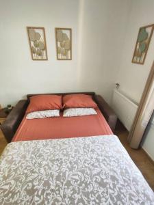 a bedroom with a bed with red sheets and two pillows at Chez Caramel à Vincennes in Vincennes
