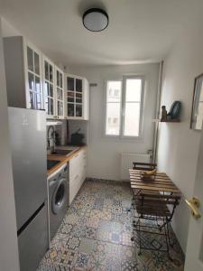 a kitchen with a refrigerator and a washing machine at Chez Caramel à Vincennes in Vincennes +4 photos