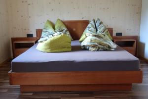 a bed with four pillows on top of it at Rumwaldhof - Wohnung Enzian in Solda