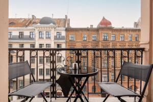 een balkon met 2 stoelen en een tafel en een gebouw bij Central & Functional Studio Riga in Rīga