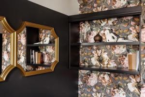 een spiegel aan een muur met bloemenbehang bij Central & Functional Studio Riga in Rīga