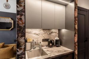 een keuken met een wastafel en witte kasten bij Central & Functional Studio Riga in Rīga +21 foto's