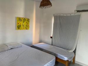 a bedroom with two beds and a window at POUSADA DOS CARDEAIS Flat 1 in Marau +2 photos