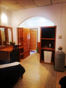 a room with a kitchen with a desk and a table at Private well priced Guesthouse available to rent in Koh Phangan
