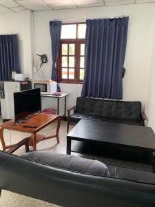 a living room with a couch and a table with a laptop at Private well priced Guesthouse available to rent in Koh Phangan