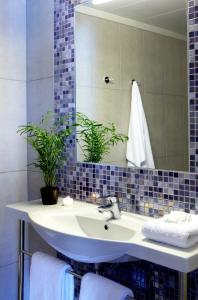 ein Badezimmer mit Waschbecken und Spiegel in der Unterkunft Mouikis Hotel Kefalonia in Argostoli