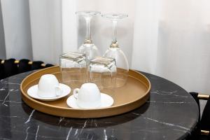 a tray with glasses and cups and saucers on a table at Maison 31 - Junior Suite in Santa Marinella