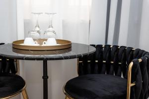 a table with chairs and glasses on top of it at Maison 31 - Junior Suite in Santa Marinella