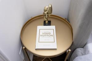 a sign on a small table with a gold pendant at Maison 31 - Junior Suite in Santa Marinella +21 photos