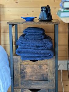 a table with a pile of towels on it at The Cabin in Bradford on Avon