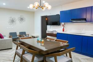 a kitchen with blue cabinets and a table and chairs at King Bed Retreat Parking Ideal Workspace in Mazatlán