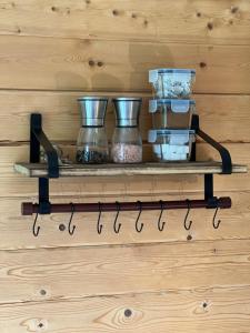a shelf with pots and pans on a wooden wall at The Cabin in Bradford on Avon