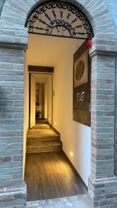 an archway leading to a hallway with wooden floors and a staircase at Affittacamere Dentro Le Mura in Ripa