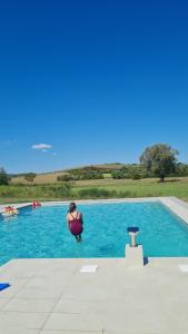 a person sitting in a chair in a swimming pool at Oaza L in Majar