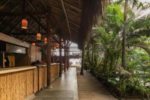 a restaurant with a bar and some palm trees at Costeño Beach in Santa Marta