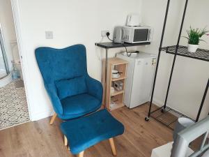 a blue chair in a room with a microwave at CNN House in Peacehaven