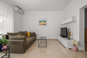 a living room with a couch and a tv at Holiday Home Katharina in Labin