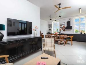 a living room with a television and a dining room at Agroturystyka SIESTA in Wola Chojnata