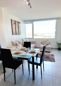 a living room with a table and chairs and a couch at Dpto cerca de Aeropuerto con piscina y zona de trabajo in Guayaquil