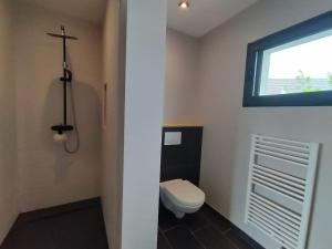 a bathroom with a white toilet and a window at Cocon familial proche des plages 10 personnes in Quimper +27 photos