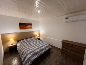 a bedroom with a bed and two lamps on tables at Finca Los Arrieros - Malargüe in Malargüe