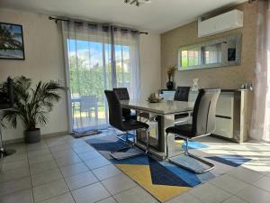 a dining room with a table and chairs at Maison très bien équipée avec piscine et au calme in Bourg-en-Bresse