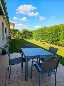 a blue table and chairs on a patio at Maison très bien équipée avec piscine et au calme in Bourg-en-Bresse