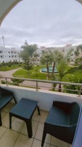 a view from a balcony with a chair and a table at Appartement meublé harhora in El Harhoura