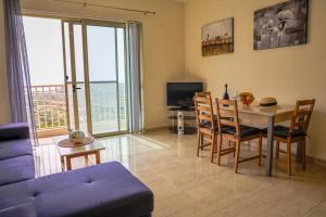 a living room with a table and a blue couch at Peaceful 2 bed, 2 bath flat & breathtaking views in Mellieħa +23 photos