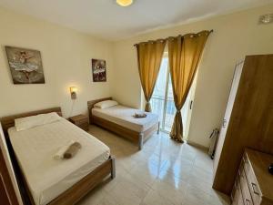 a bedroom with two beds and a window at Peaceful 2 bed, 2 bath flat & breathtaking views in Mellieħa