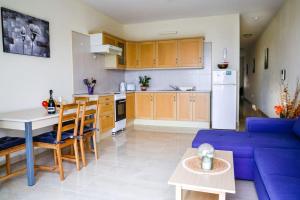 a living room with a blue couch and a kitchen at Peaceful 2 bed, 2 bath flat & breathtaking views in Mellieħa