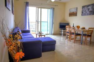 a living room with a blue couch and a table at Peaceful 2 bed, 2 bath flat & breathtaking views in Mellieħa