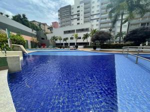 a large pool with blue water in a building at Flat Veredas 305 com ar condicionado sala - 300 metros do Hot Park in Rio Quente