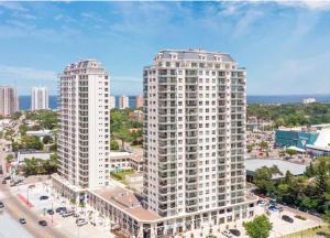 Deux grands bâtiments blancs dans une ville avec des voitures dans l'établissement Espectacular Monoambiente Nuevo en Place Lafayette piso 7 Punta del Este, à Punta del Este