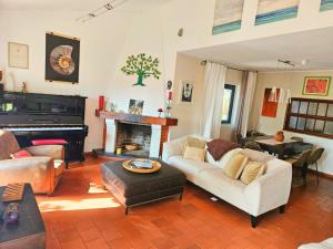 a living room with a couch and a piano at Casa Seahorses b in Sintra