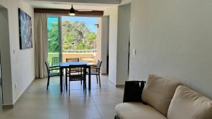 a living room with a couch and a table and chairs at Villas Coral Huatulco in Santa Cruz Huatulco