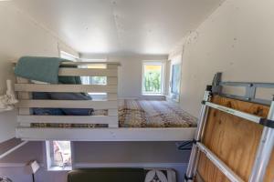 a small room with two bunk beds in a tiny house at Little Red Caboose in Oakhurst