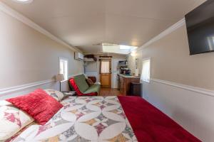 a bedroom with a bed and a living room at Little Red Caboose in Oakhurst
