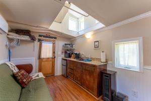 a living room with a couch and a kitchen at Little Red Caboose in Oakhurst