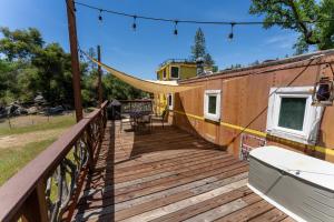 a wooden deck with a hammock on it at Little Red Caboose in Oakhurst