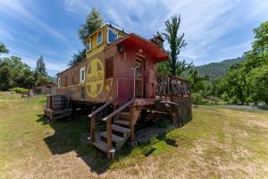 an old train car sitting in a field at Little Red Caboose in Oakhurst