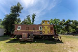 an old train car sitting in a field at Little Red Caboose in Oakhurst