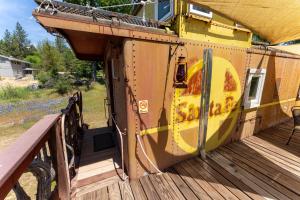 a train sitting on top of a wooden deck at Little Red Caboose in Oakhurst
