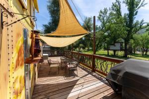 a wooden deck with a hammock and a table and chairs at Little Red Caboose in Oakhurst
