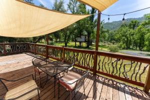 a deck with a table and chairs and a view at Little Red Caboose in Oakhurst