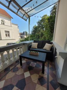 a patio with a couch and a table on a balcony at STAY Studio 1 zentral Balkon Parkplatz in Bad Pyrmont