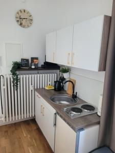 a kitchen with a sink and a clock on the wall at STAY Studio 1 zentral Balkon Parkplatz in Bad Pyrmont